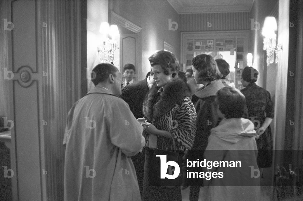 Rita Hayworth speaking with a man, 1961 (b/w photo)