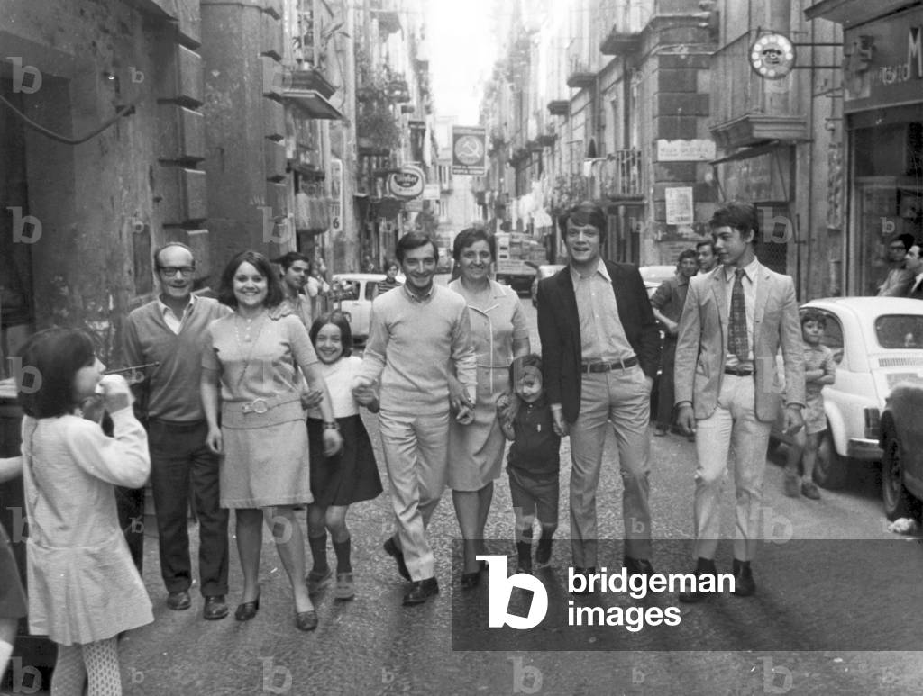 Massimo Ranieri walking along the street with his family, Naples, Italy