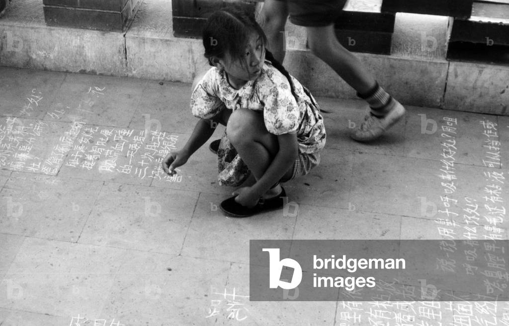 A child writing on the pavement