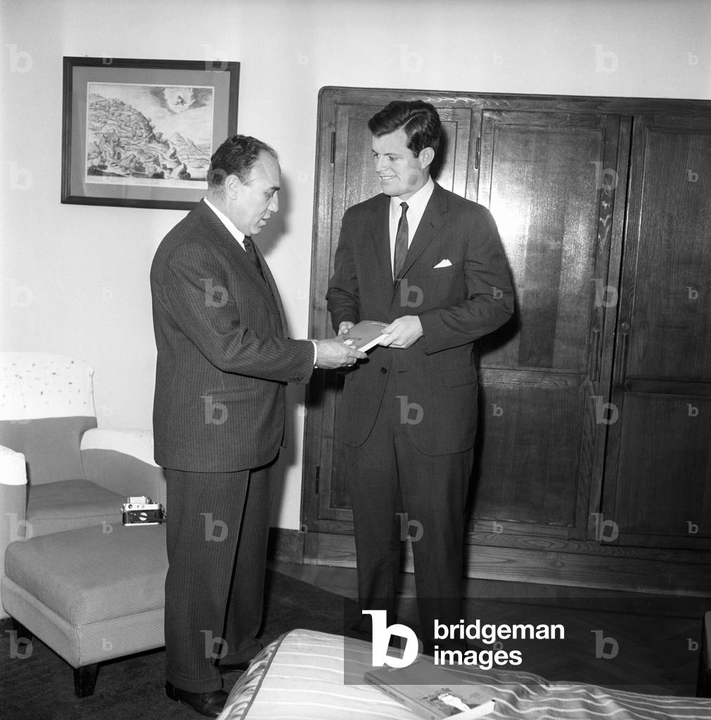 Ted Kennedy hands over to the journalist Livio Pesce a copy of the book 'A Strategy of Peace' of the older brother, the President of the USA, 1961 (b/w photo)