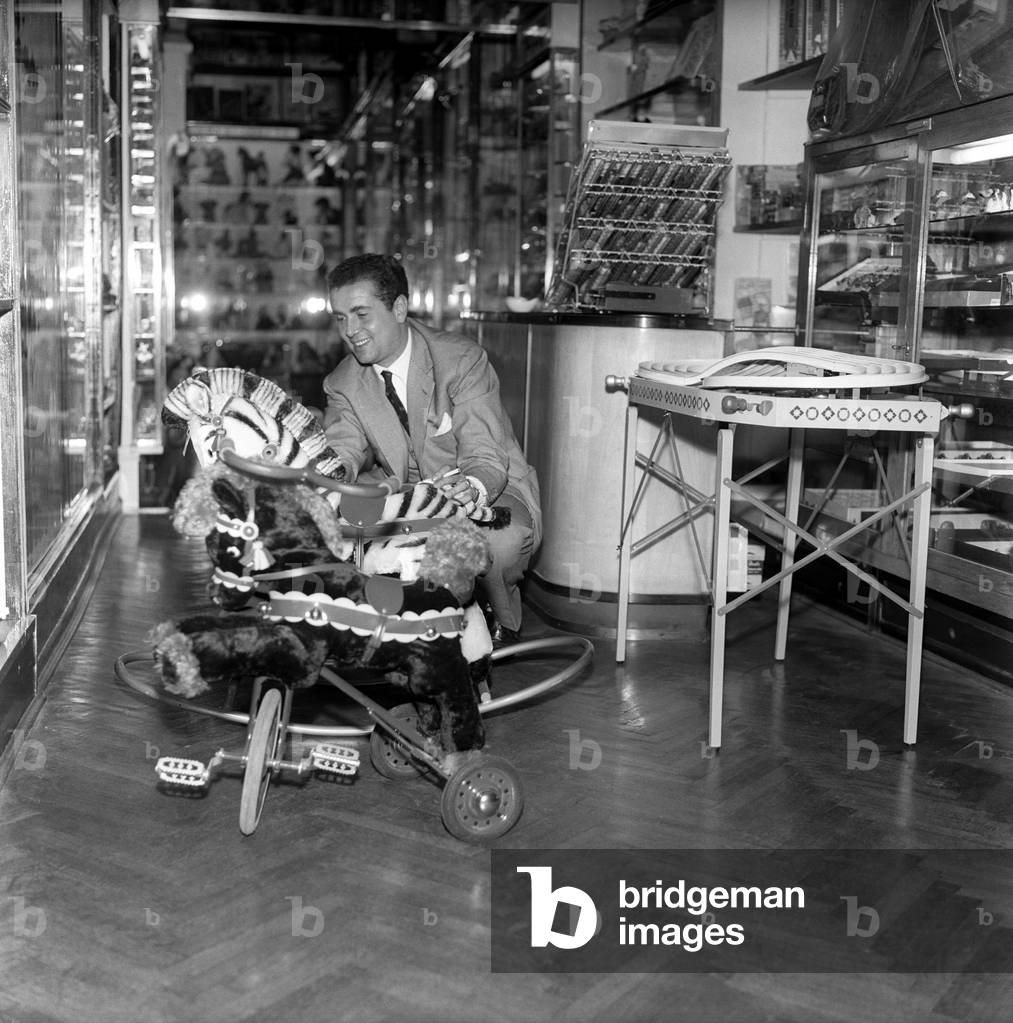 Enzo Tortora looking at a rocking horse in a toy shop