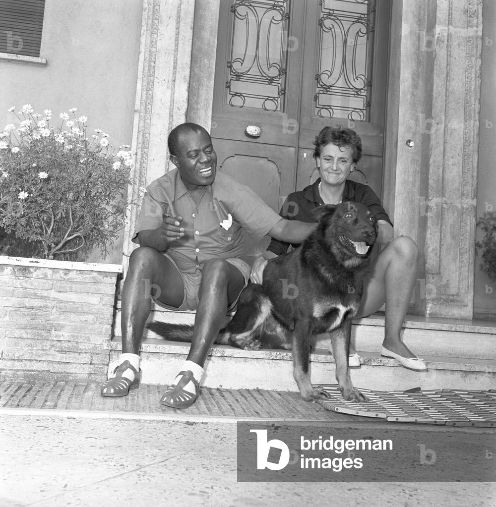 Louis Armstrong caressing a dog, 1959 (b/w photo)