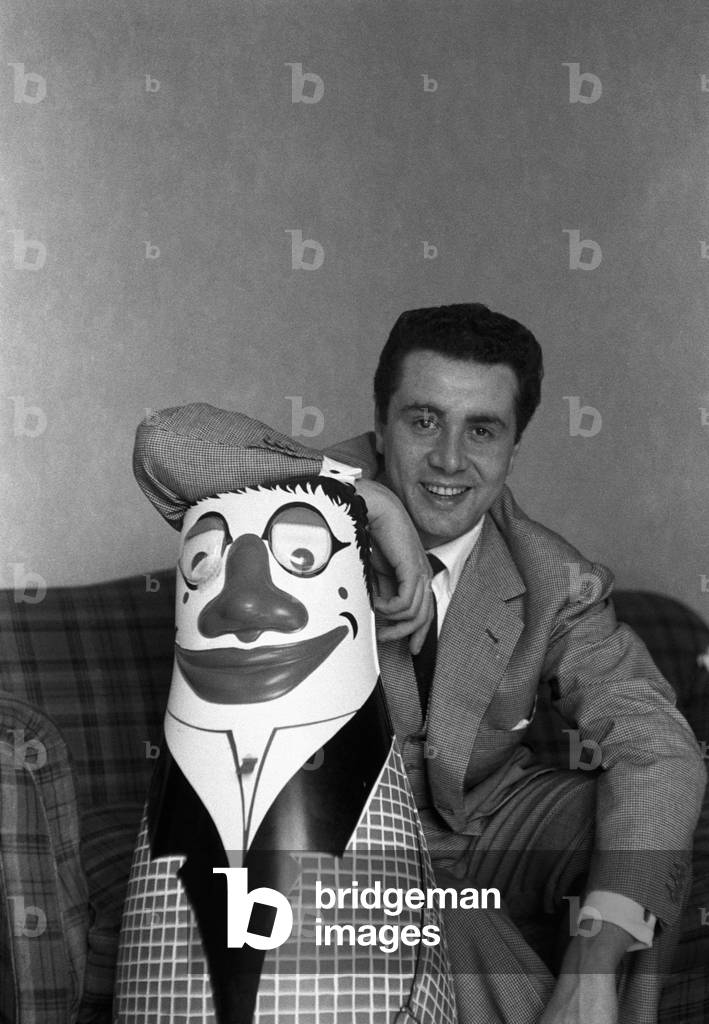 Enzo Tortora smiles posing on a rubber doll