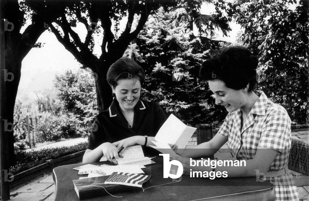 Two students reading letters in a garden, Alba, Italy