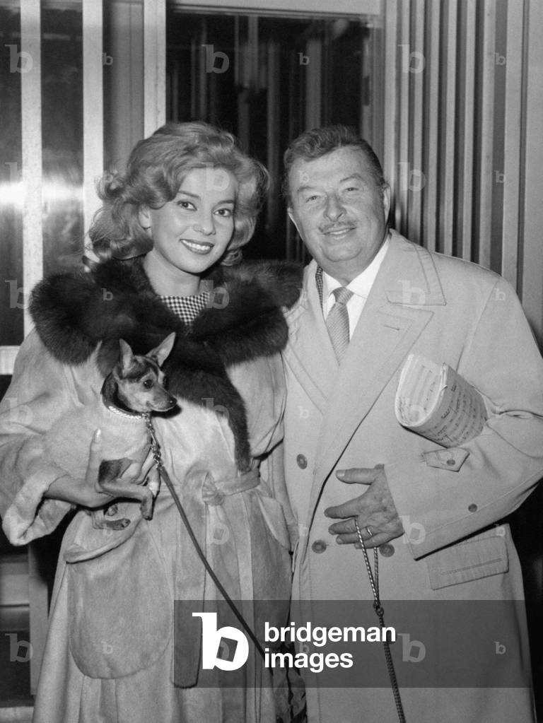 Abbe Lane smiling with Xavier Cugat and a dog
