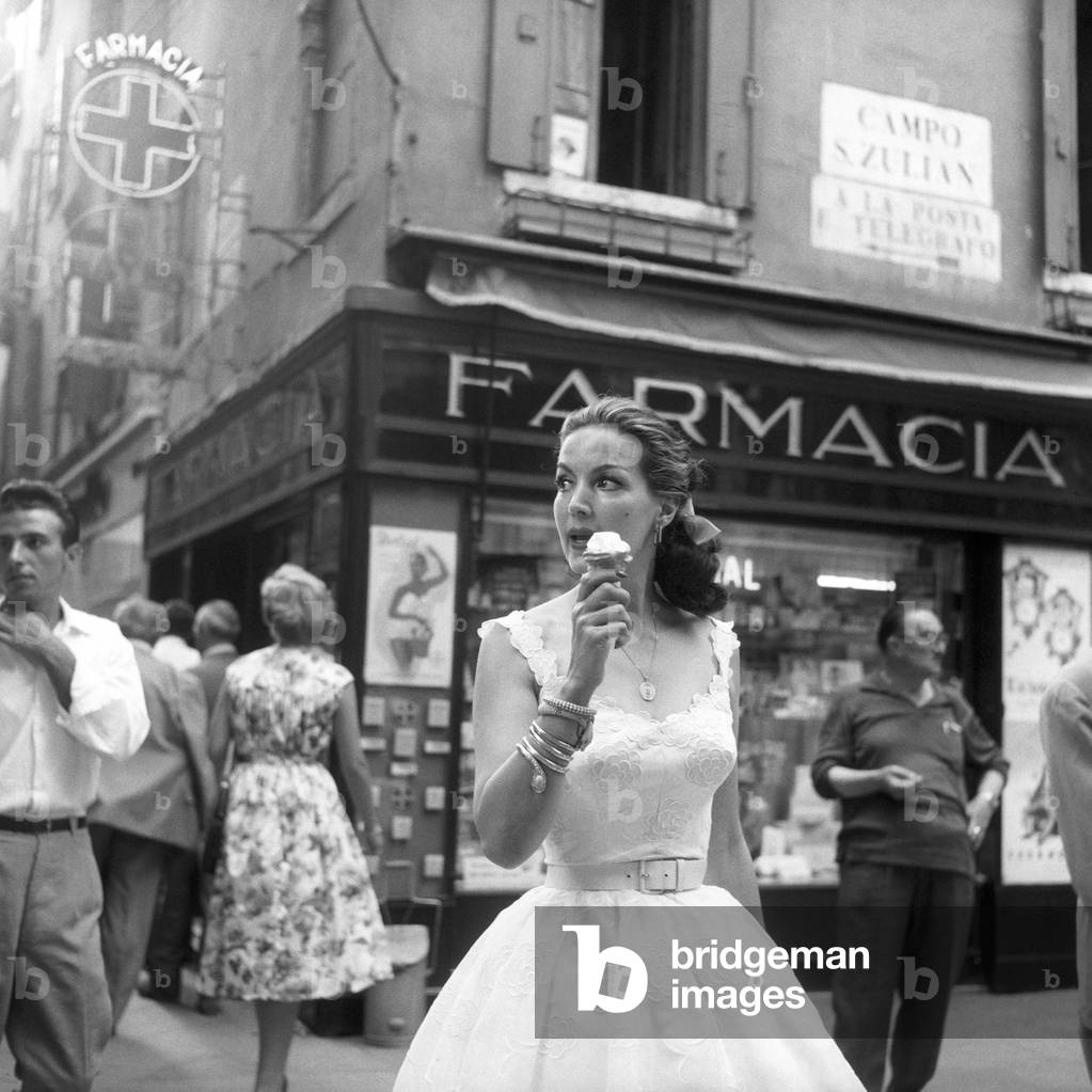 Maria Félix eating an ice cream in front of a pharmacy