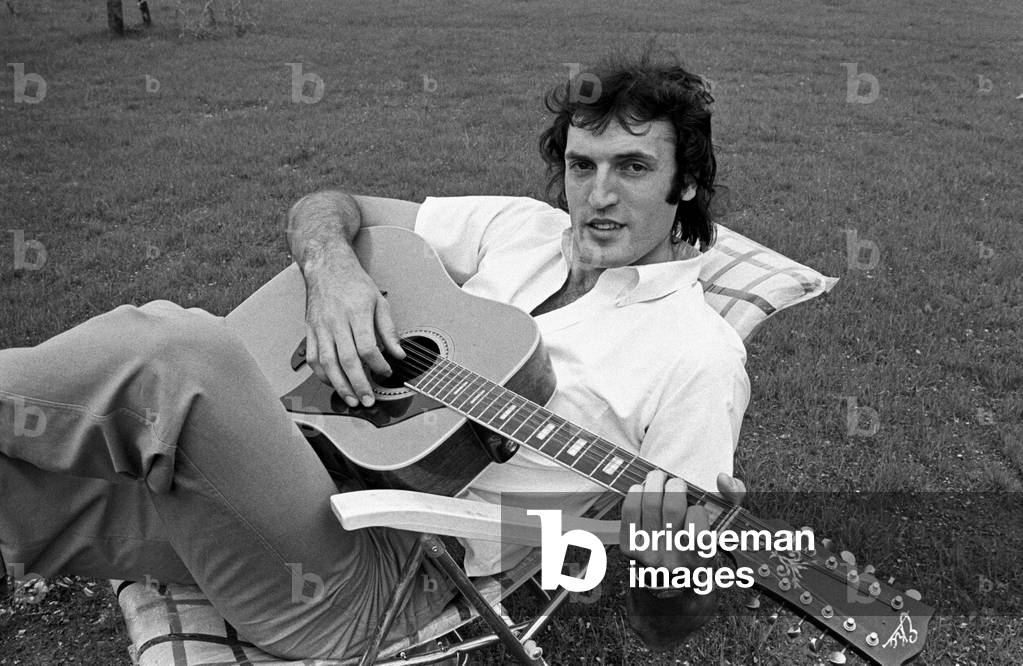 Dino Meneghin sitting with a guitar