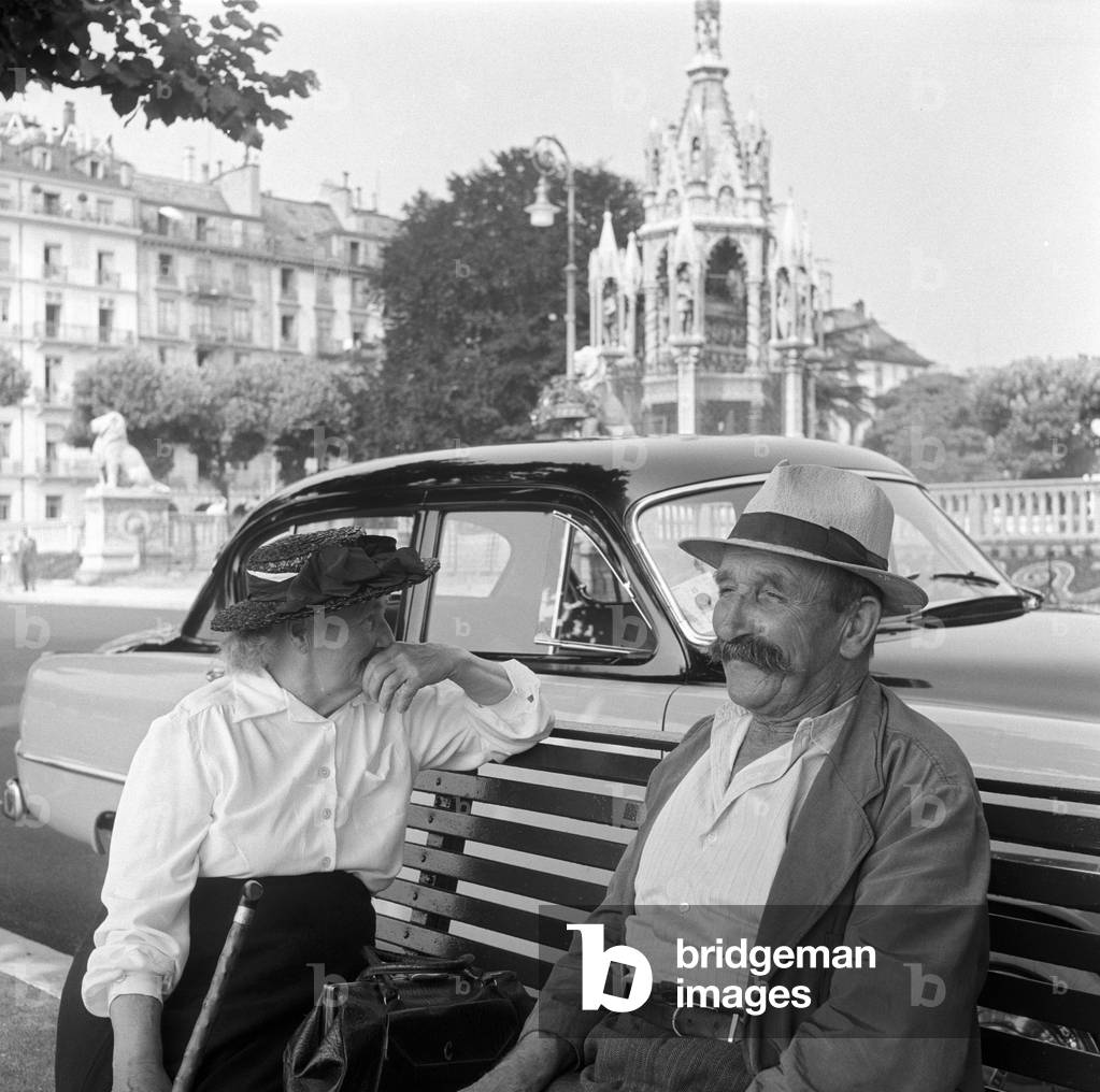 Two people sitting on a bench in front of the Brunswick Monument in Geneva, Geneva, Switzerland