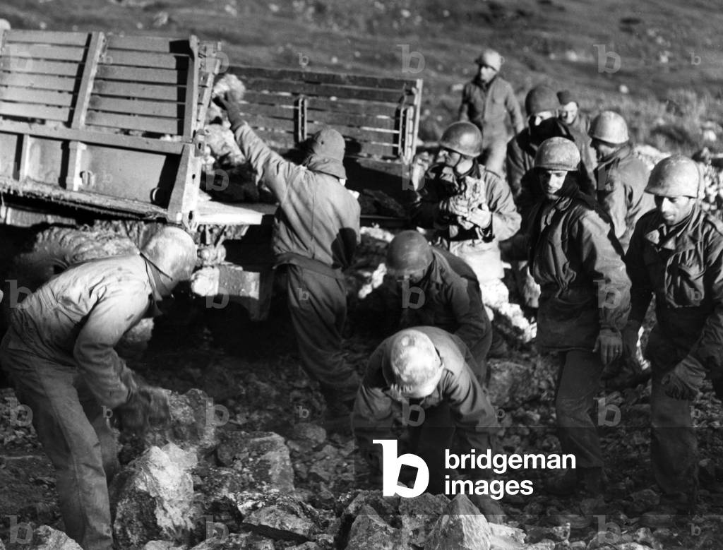 U.S. soldiers picking up stones