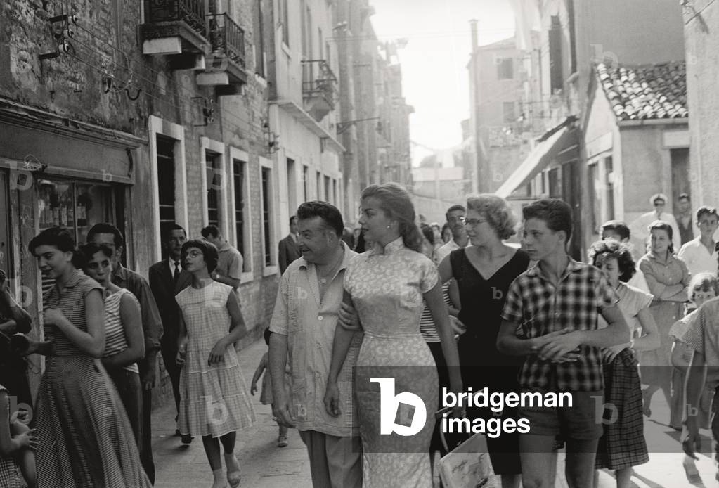 Abbe Lane among the streets of Venice with her husband Xavier Cugat and a lot of fans, 1956 (b/w photo)