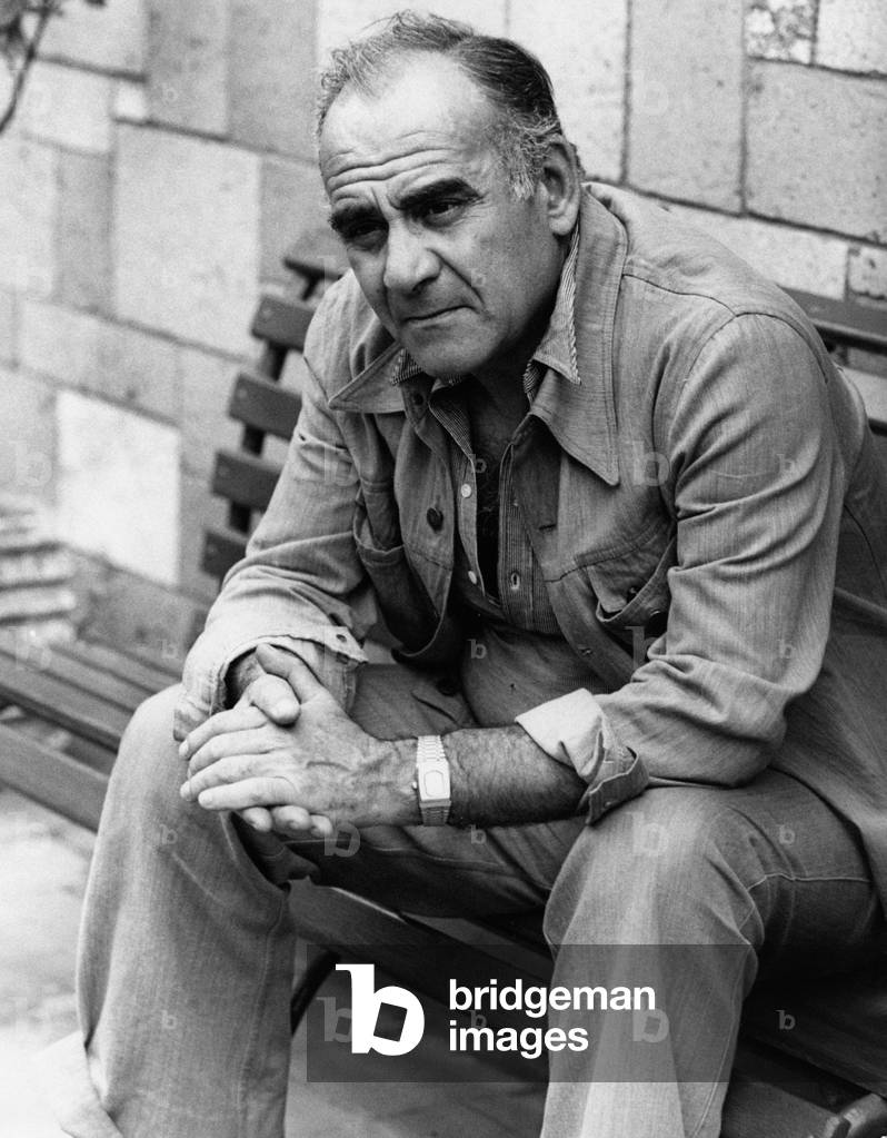 Vittorio Caprioli seated on a bench