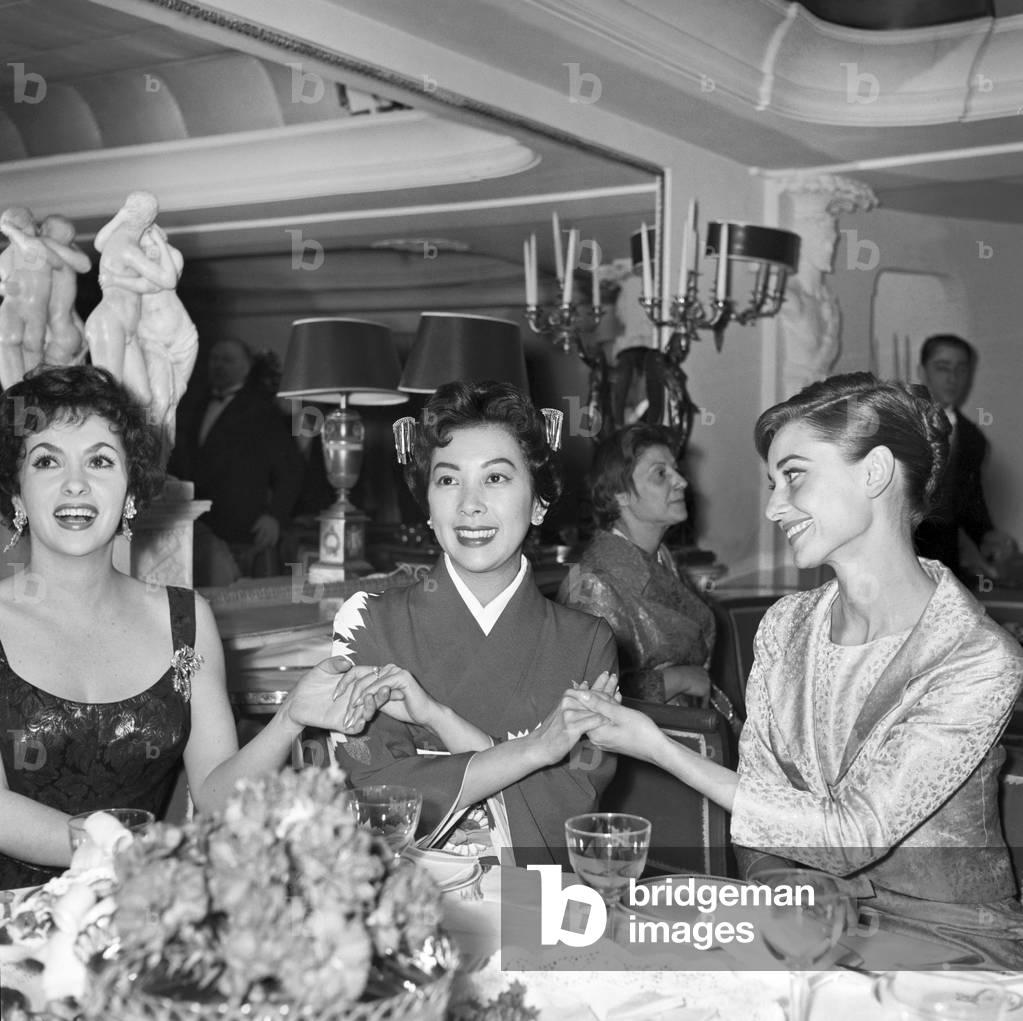 Audrey Hepburn, Gina Lollobrigida and Miiko Taka hand in hand, Italy, 1958 (b/w photo)