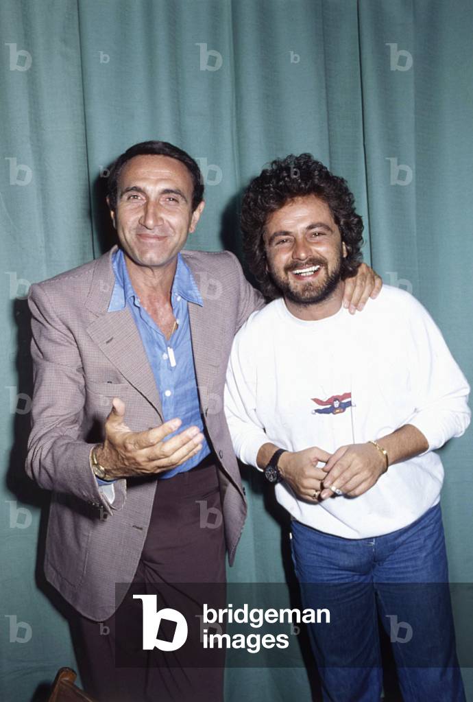 The comedian Beppe Grillo and the TV host Pippo Baudo in the backstage of Vota la voce, 1979 (b/w photo)