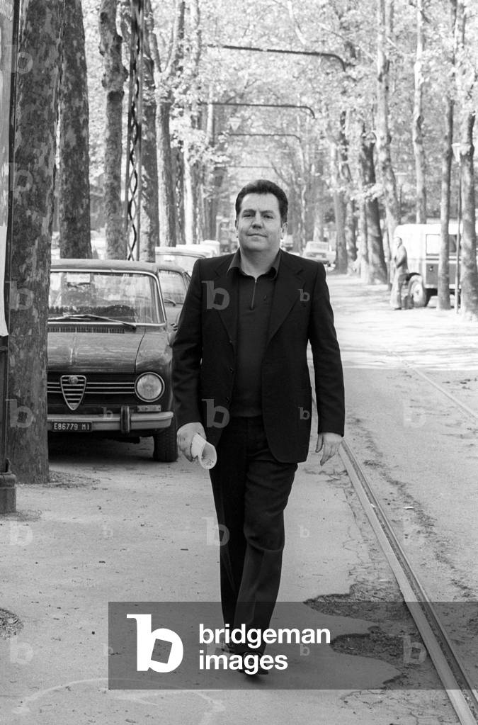 Giuseppe Pontiggia walking down a tree-lined street in Milan