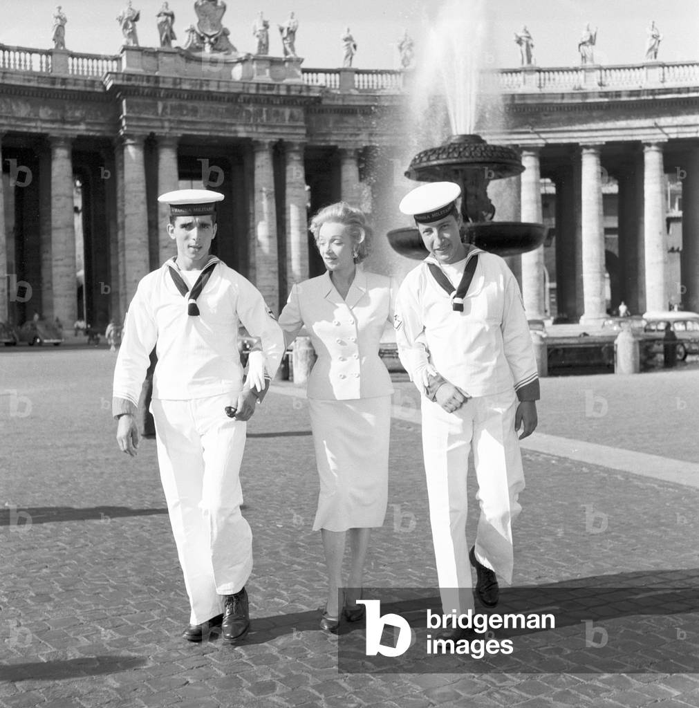 Marlene Dietrich with two seamen on Saint Peter's Square, 1957 (b/w photo)