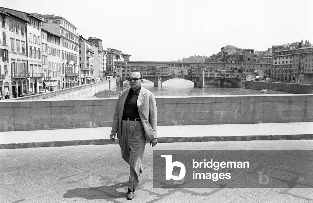 Vasco Pratolini going across Alle Grazie Bridge, Florence, Italy, 1960