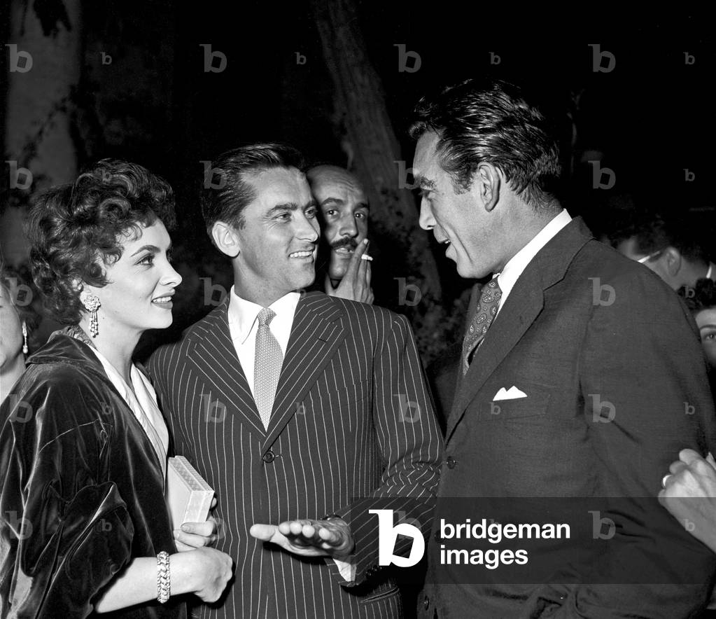 Gina Lollobrigida and her husband Milko Skofic talking to Anthony Quinn, Rome, Italy, 1954 (b/w photo)