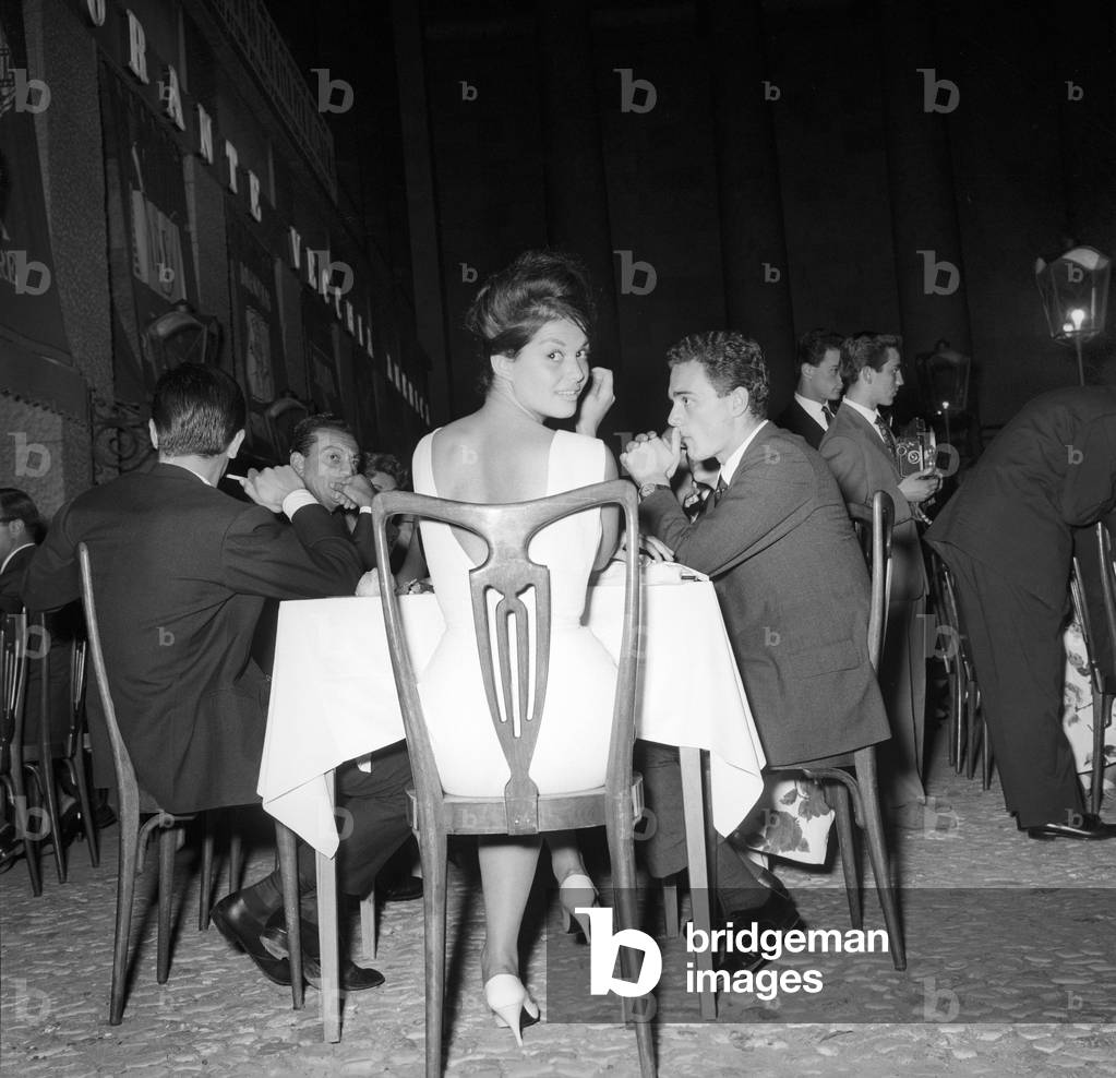 Claudia Cardinale sitting at the restaurant, Unspecified, 1961 (b/w photo)