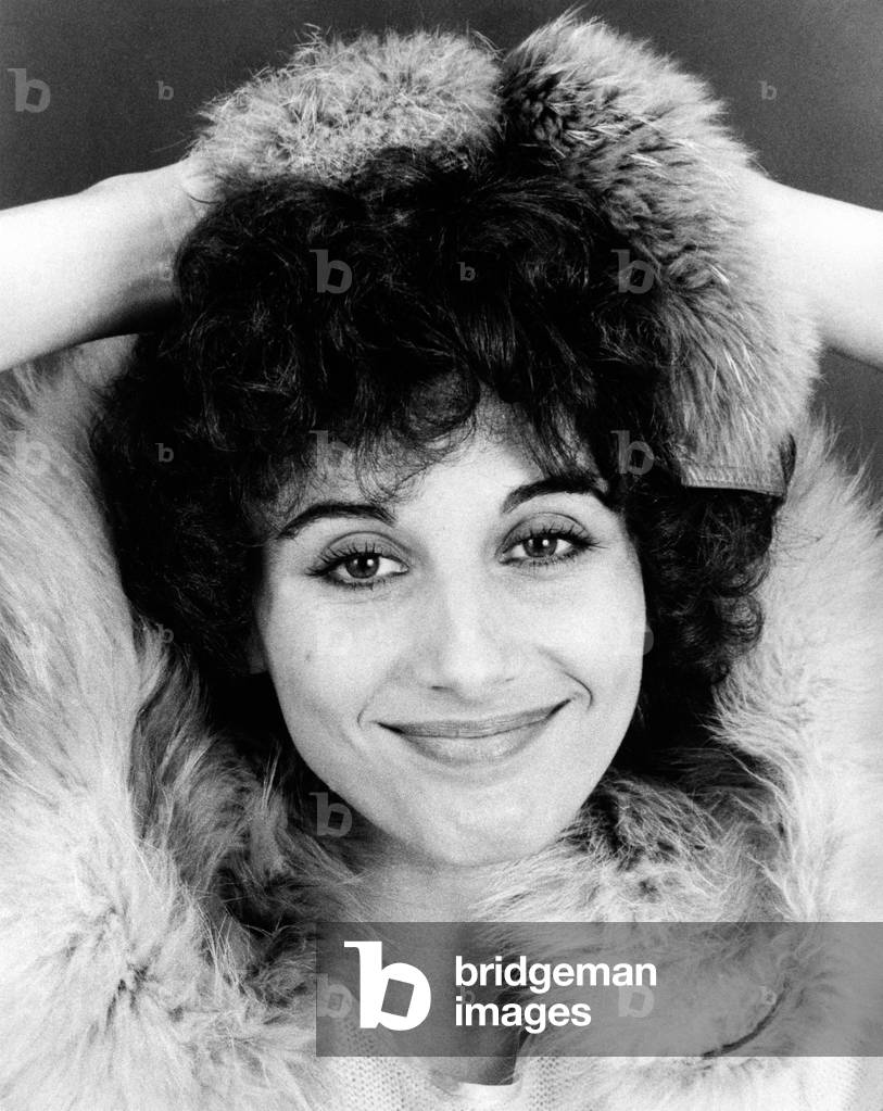 Paola Pitagora in a joking pose covers her head with a fur stole