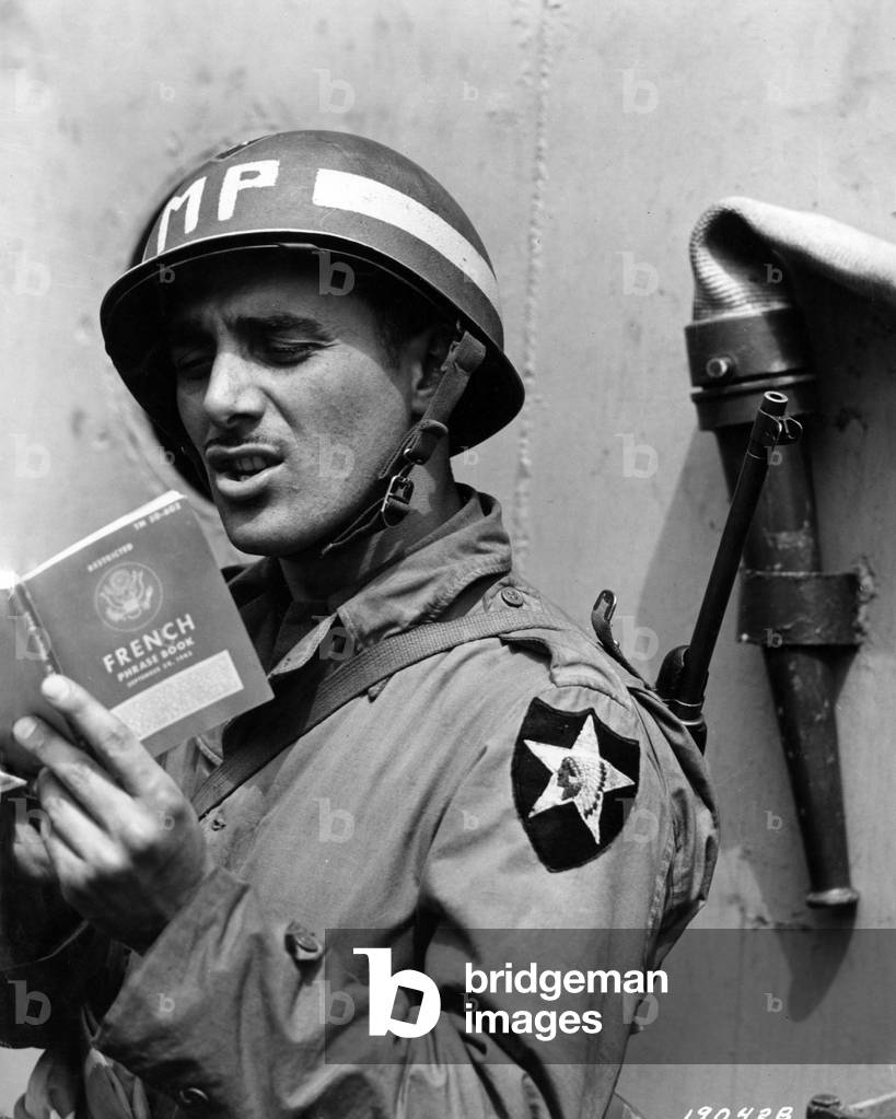 An Italian-American soldier consulting a French phrase book