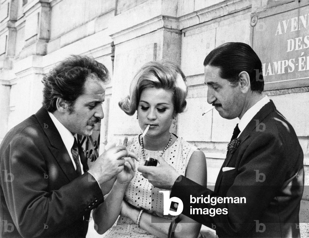 Don Jaime de Mora y Aragon lighting a cigarette to Liana Orfei beside Domenico Modugno, Italy