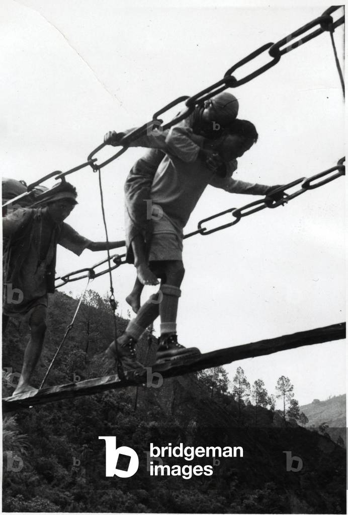 A Sherpa carrying his wife on his shoulders