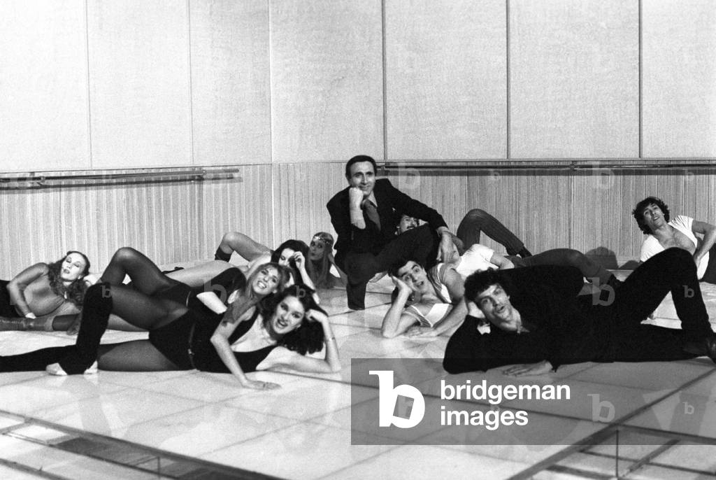 Italian TV host Pippo Baudo posing with the ballet company of a TV show, Italy, 1976 (b/w photo)