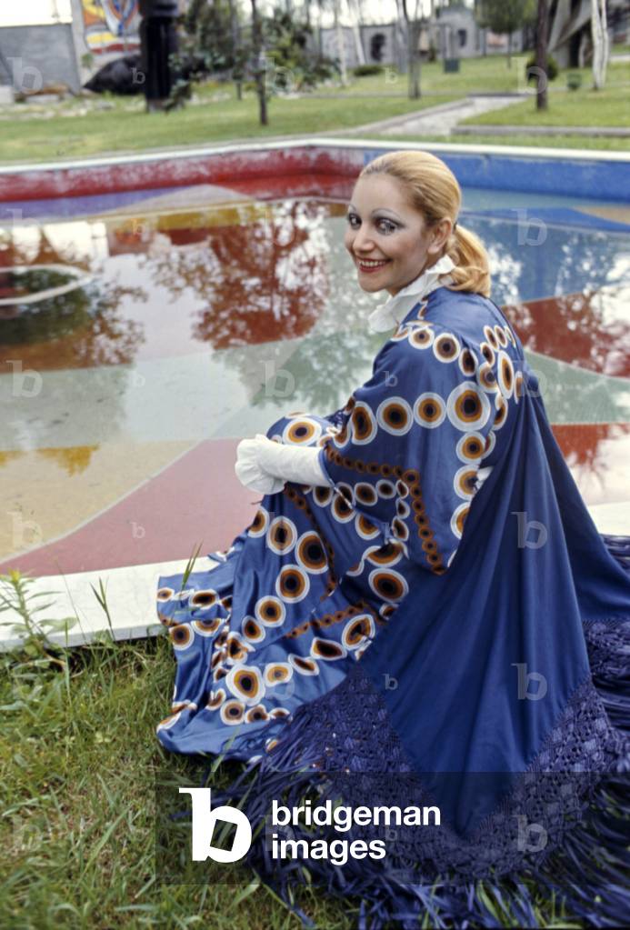 Mia Martini seated in front of a pool