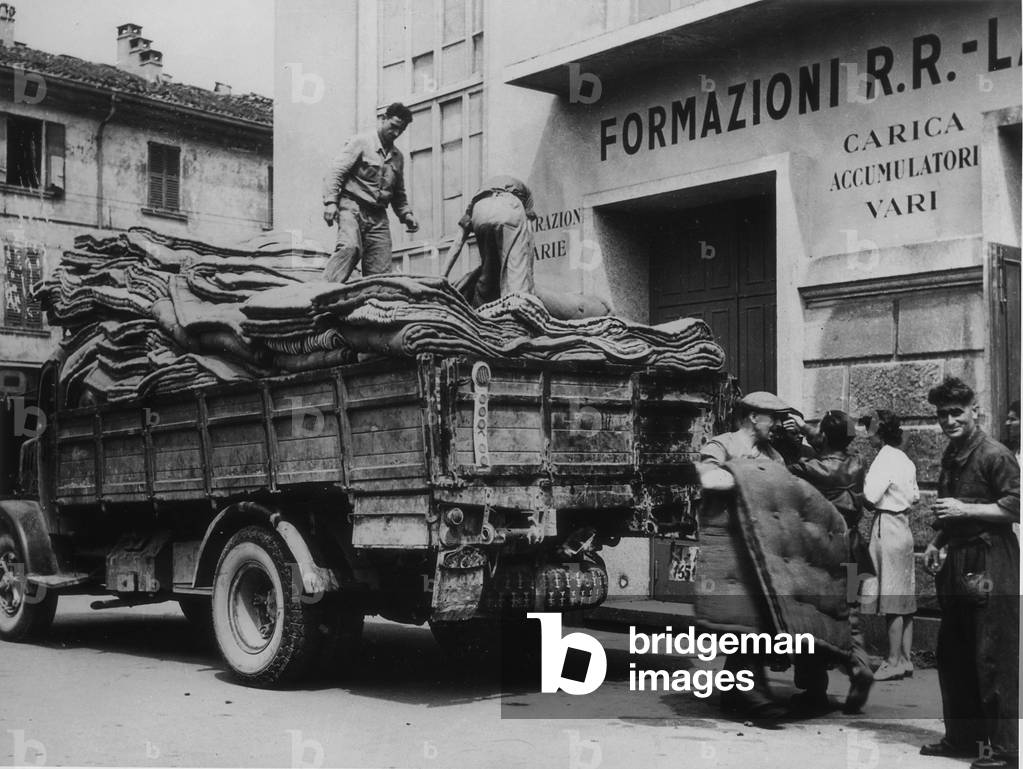 Some matresses are unloaded from a truck