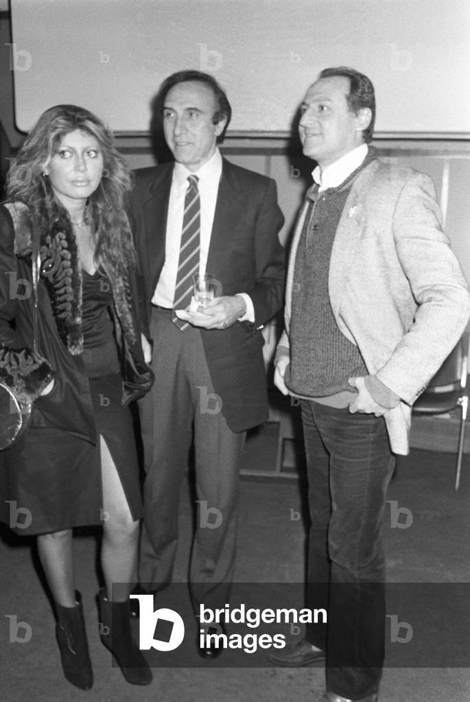Italian TV host Pippo Baudo with Alida Chelli, his girlfriend, and Renzo Arbore at a cocktail party, Italy, 1976 (b/w photo)