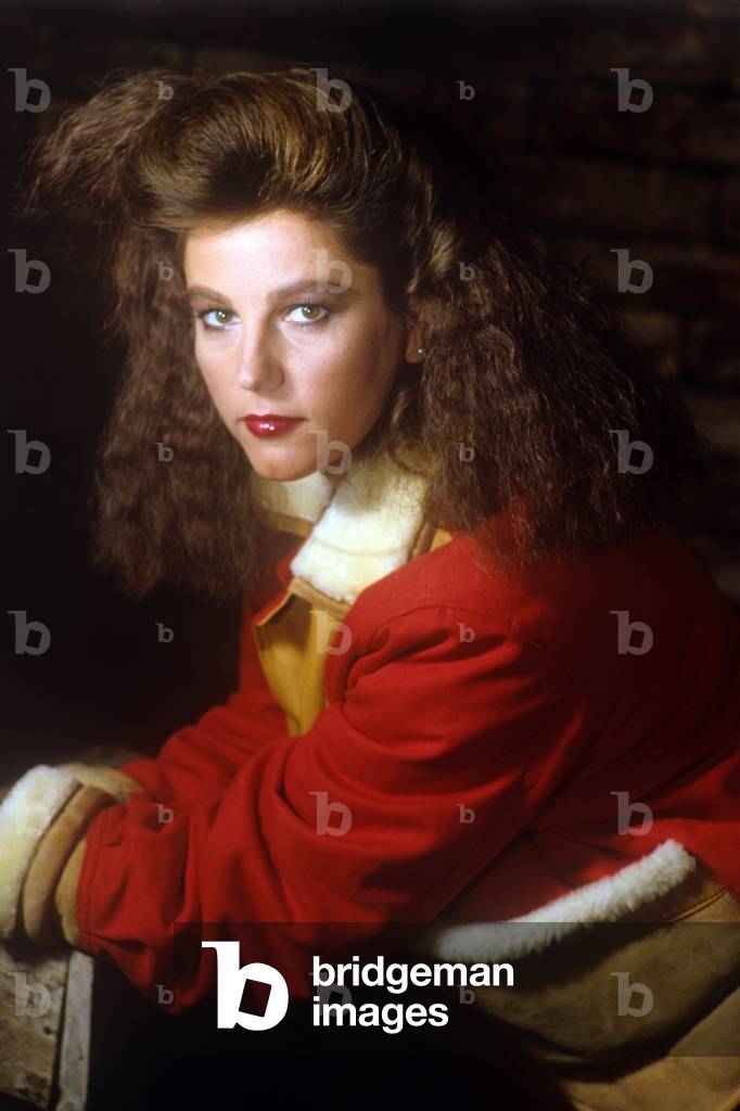 Stefania Sandrelli with hair flowing and a red bomber jacket