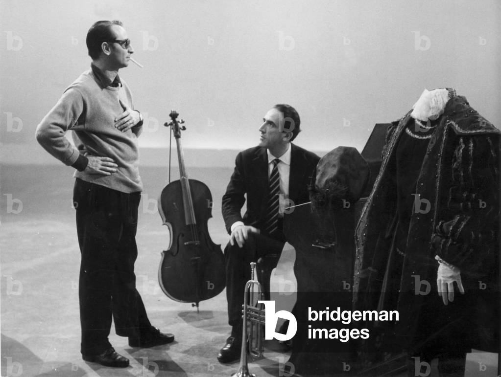 Arnoldo Foà and Enzo Trapani onstage, surrounded by stage costumes and musical instruments, Italy