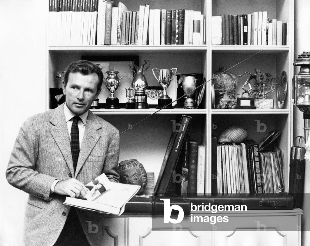 Jacques Sernas in front of a bookcase