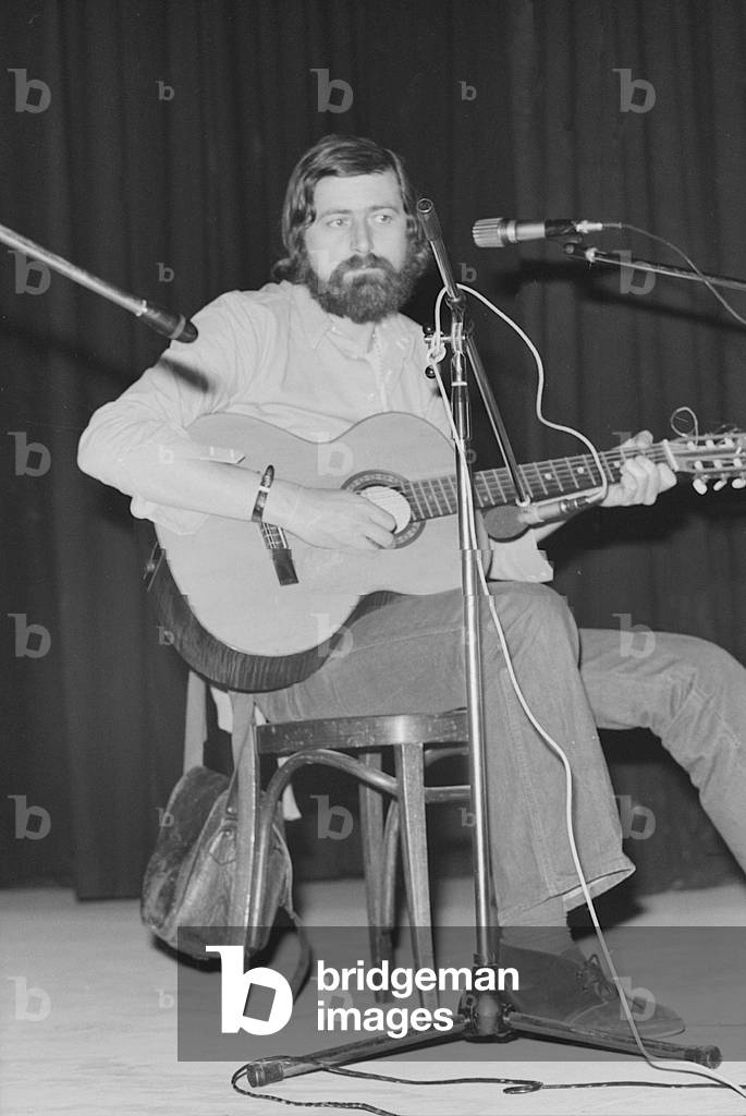 Francesco Guccini performing on stage at Teatro Quartiere in Quarto Oggiaro, Italy, 1976 (b/w photo)