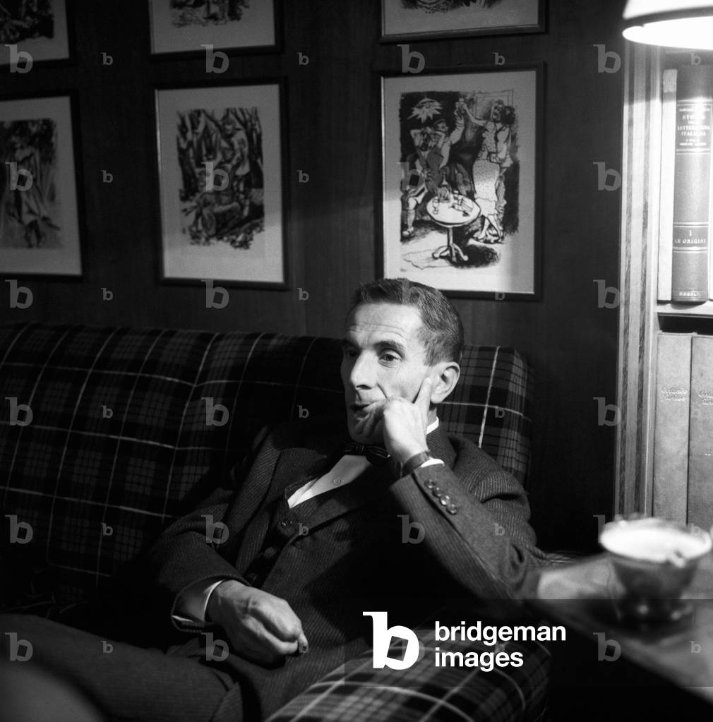 Dino Buzzati seated in a couch