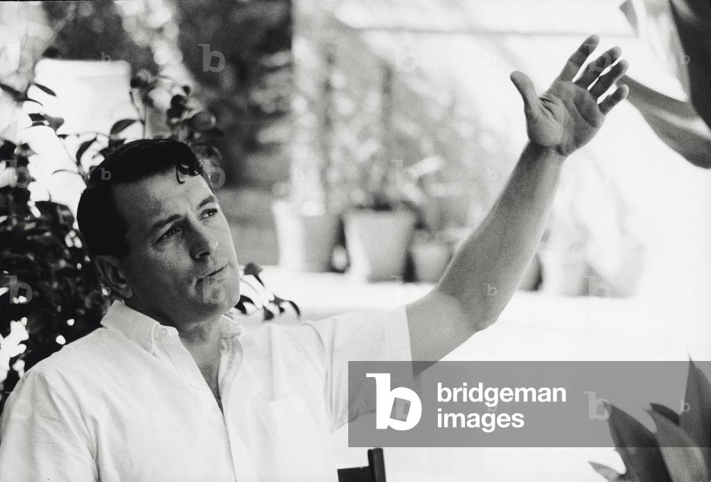 Rock Hudson with his arm raised