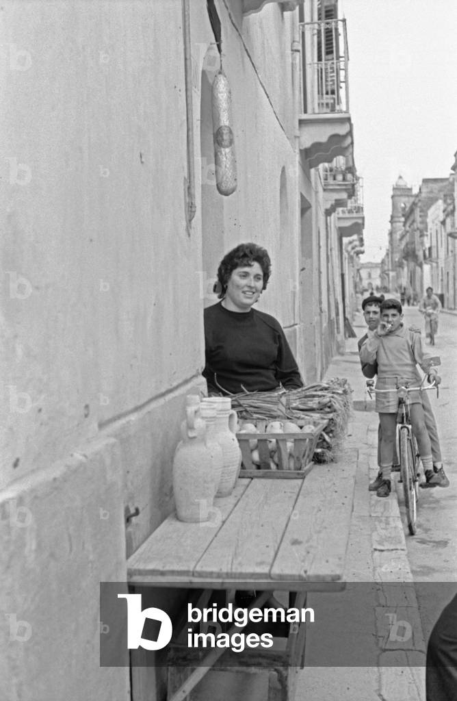 A woman selling vegetables on a street in Menfi, Menfi, Italy