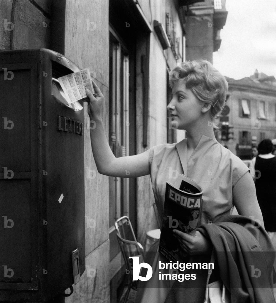 A young woman mailing her mail, Italy, 1958 (b/w photo)