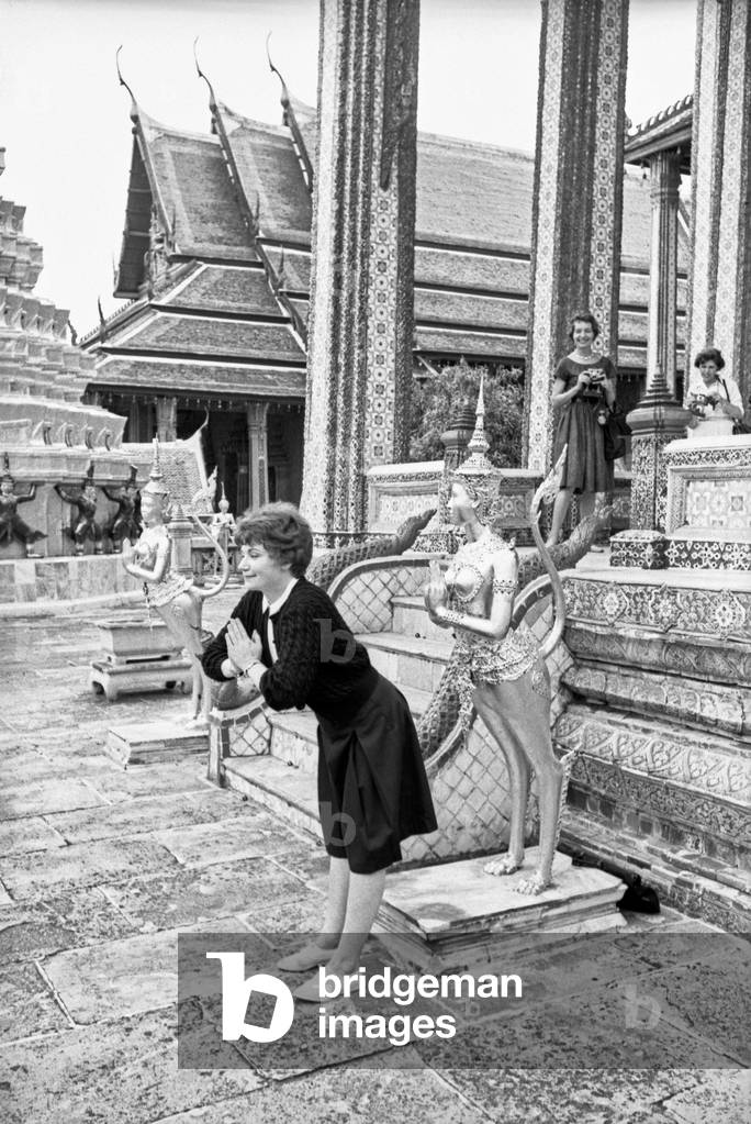 A woman imitating the statue of a Kinnara at Wat Phra Kaew Buddhist Temple, Bangkok, 1961 (b/w photo)