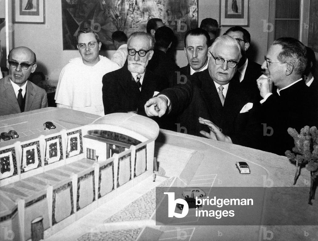 Aldo Fascetti pointing at the scale model of a building