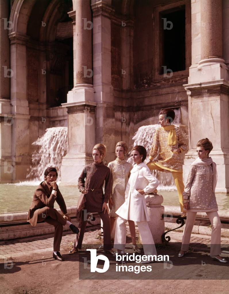 Valentino surrounded by models wearing his dresses