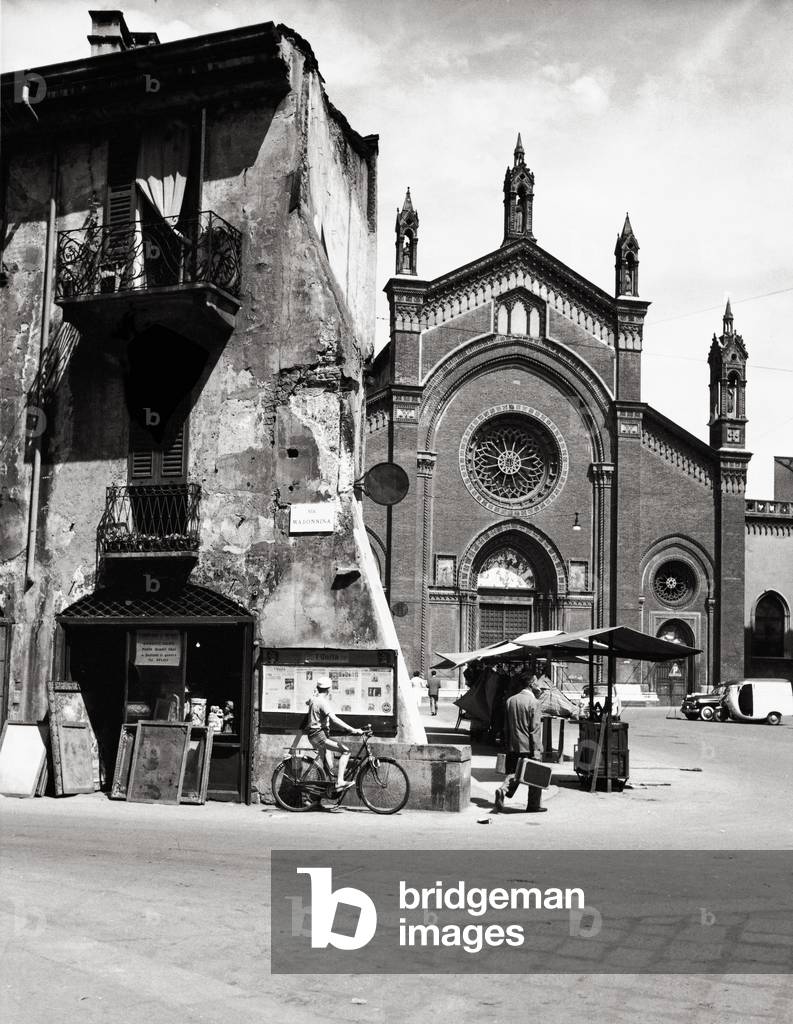 Junk shop in Via Madonnina and the church of Santa Maria del Carmine, Italy, 1950 (b/w photo)