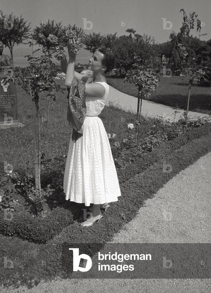 Claire Bloom fondles a rose in bloom