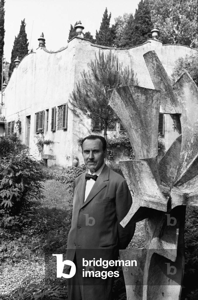 Alessandro Bonsanti posing beside a sculpture, Fiesole, Italy, 1966