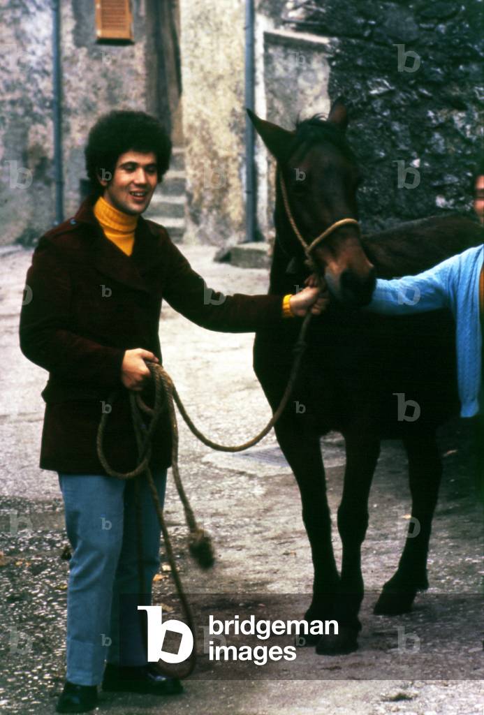 Lucio Battisti smiling beside a horse