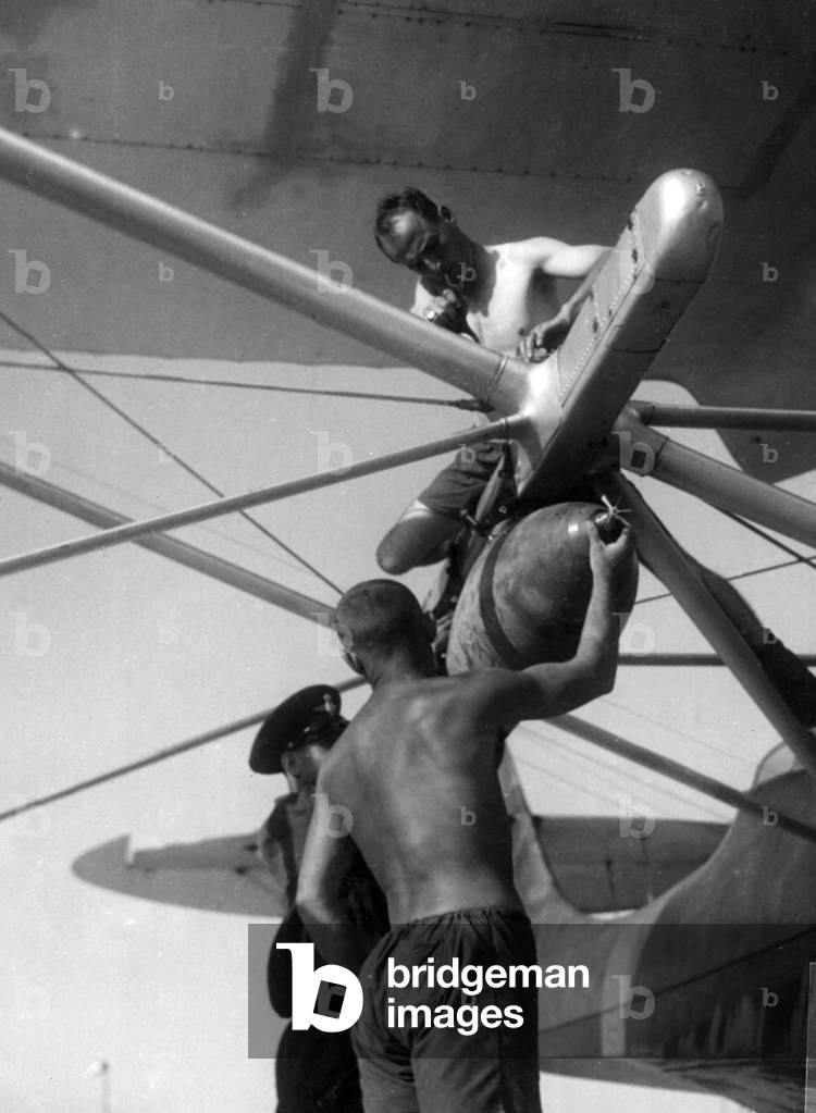 Loading a bomb on a seaplane