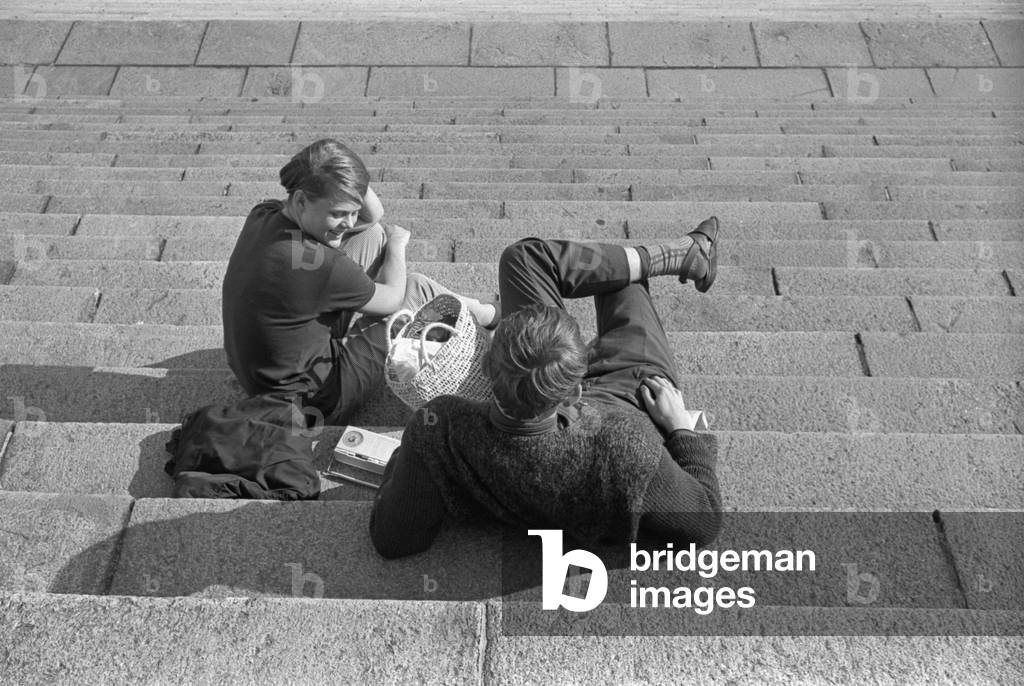 Two young people chatting on a staircase, Finland, 1960s (b/w photo)