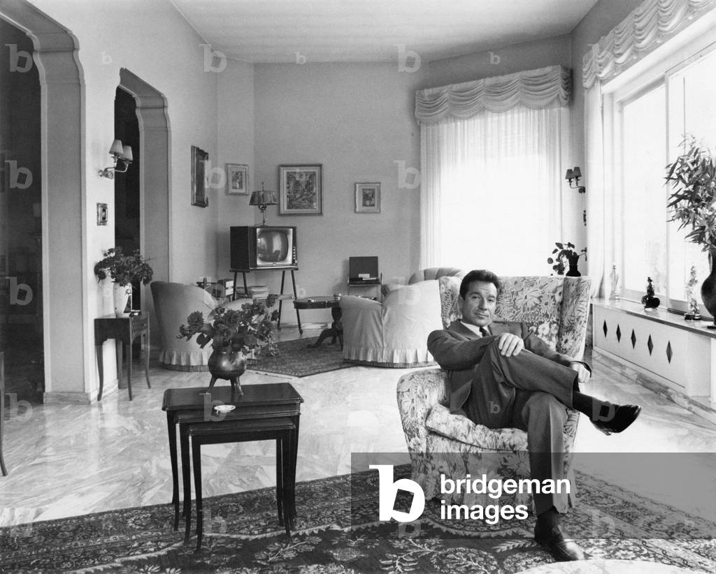 Ugo Tognazzi sitting in his living room