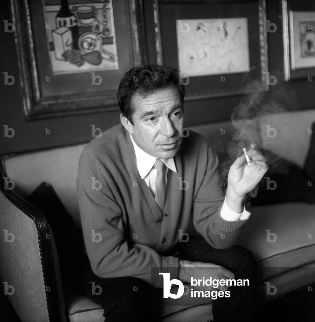 Ugo Tognazzi sitting with a cigarette in his hand