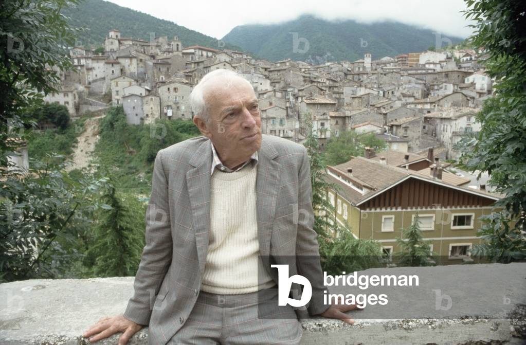 Saul Bellow sitting on a wall